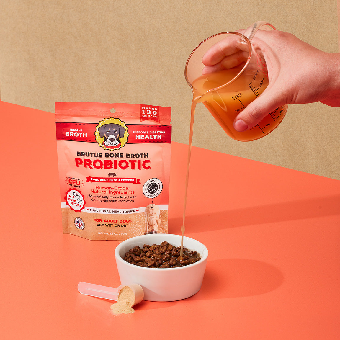 Brutus Bone Broth Probiotic Pork Bone Broth Powder. Pouring liquid broth into bowl of kibble
