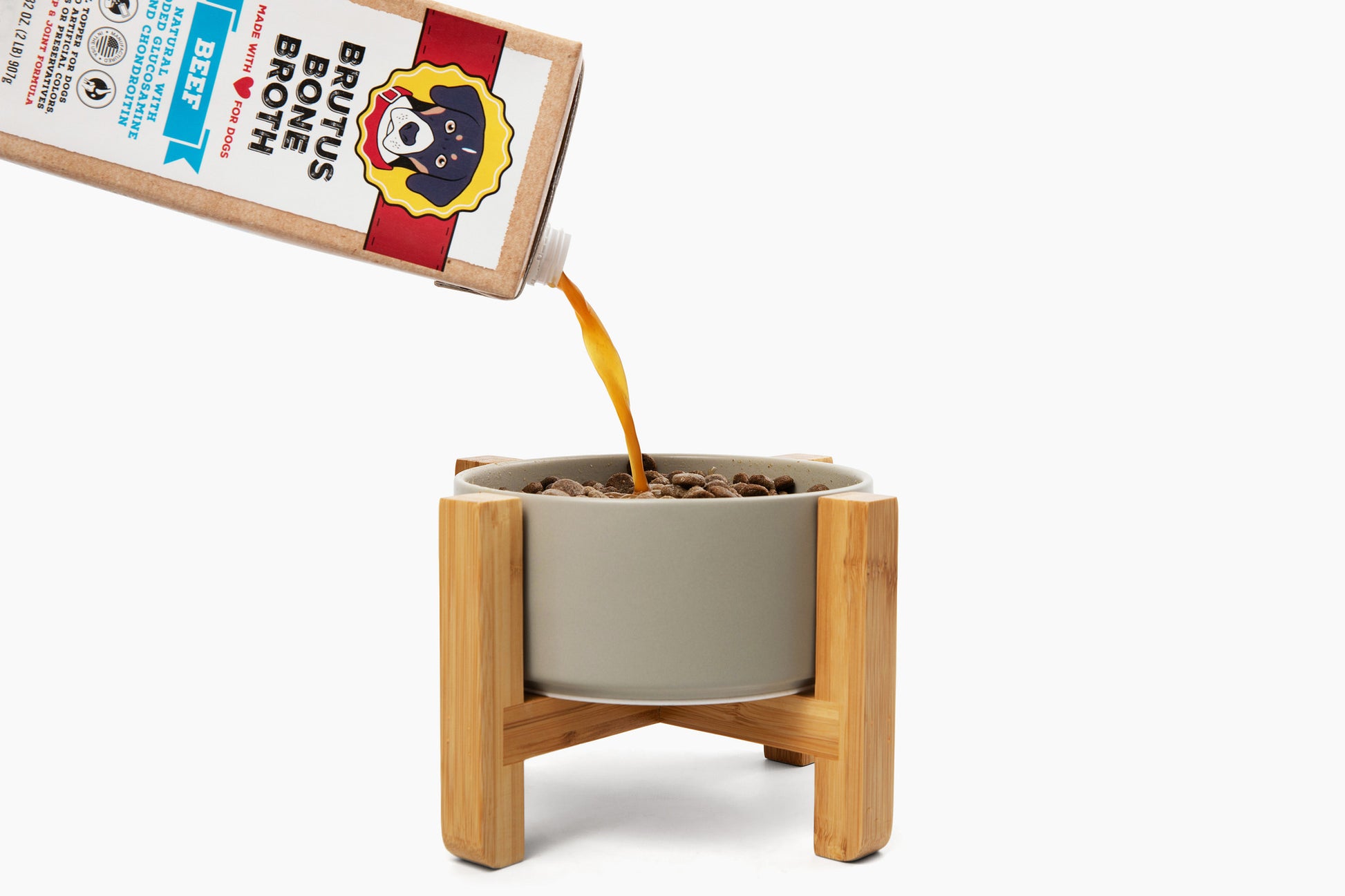 Brutus Bone Broth Beef pouring into a bowl of kibble