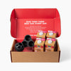Open Goat Milk Club for Dogs box with four cartons and a black silicone ball; red lid reads GIVE THEM THEIR BEST DAY