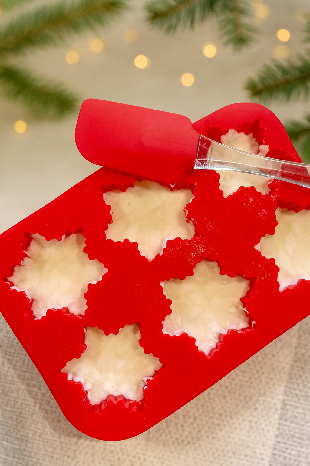 Red silicone mold with snowflake-shaped dough being filled in a festive setting.