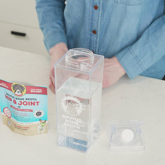 A man scoops Brutus Bone Broth Hip & Joint Mega Pack and pours it into the Brutus Shaker cup.